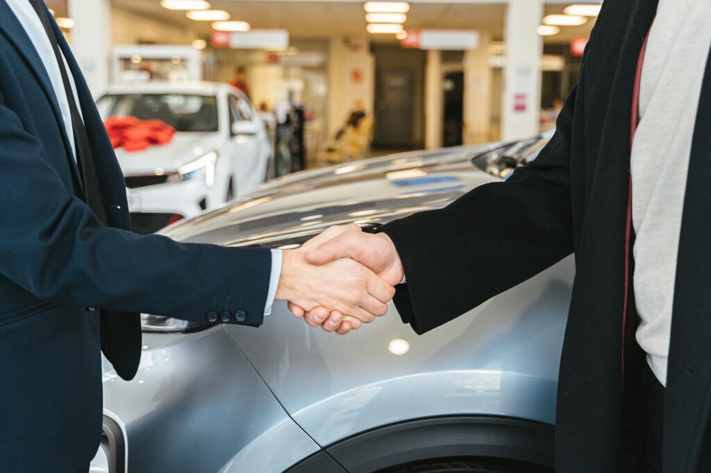 Person calculating the true cost of owning a car with paperwork and receipts