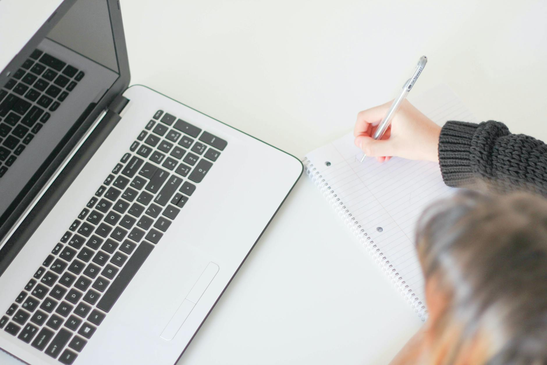 Freelancer working at a coffee shop writing on a laptop