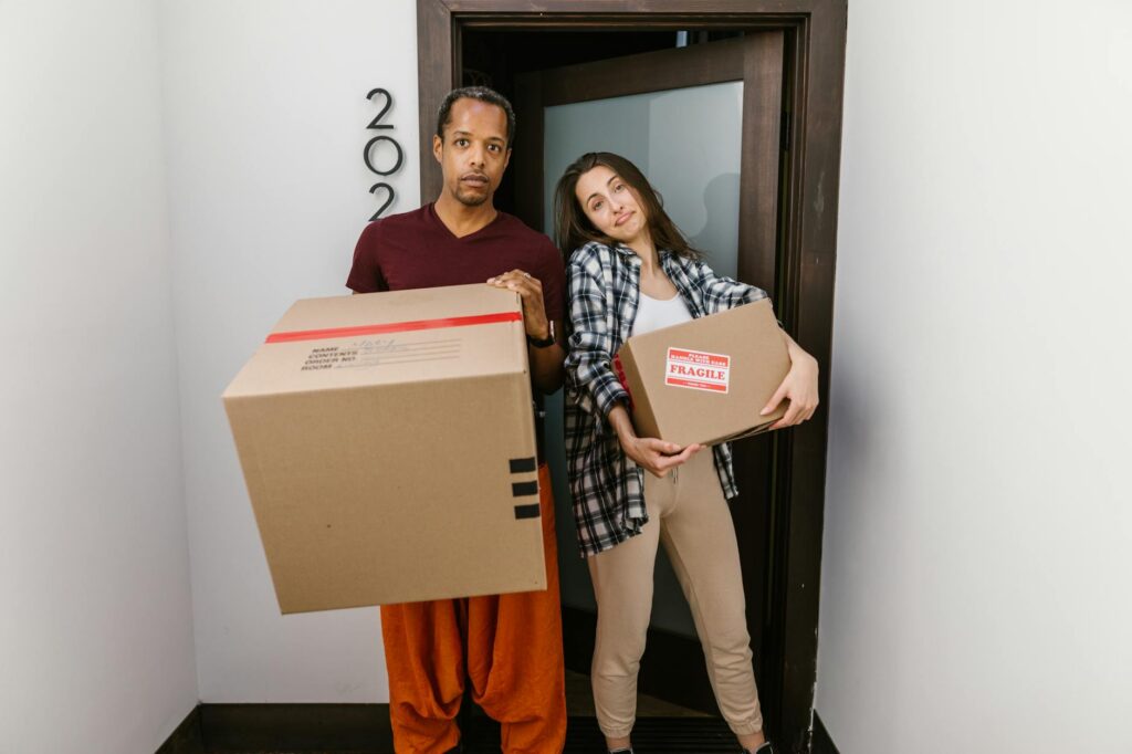 Person moving boxes into a first apartment