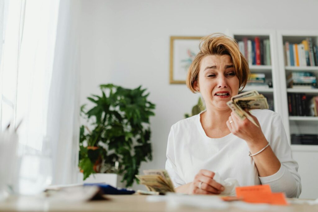 Woman counting money and looking stressed about student loan debt