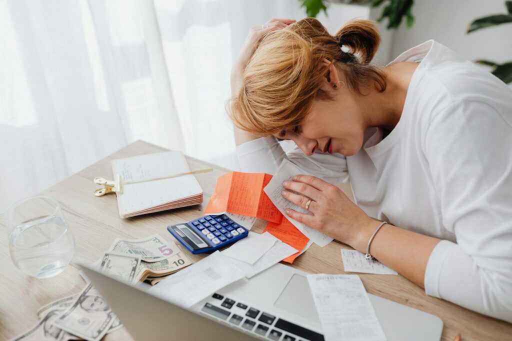 Person stressed looking at bills representing an unexpected financial expense